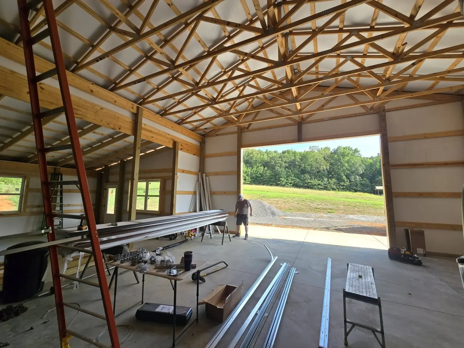 Garage door track and hardware staged inside a new pole barn build