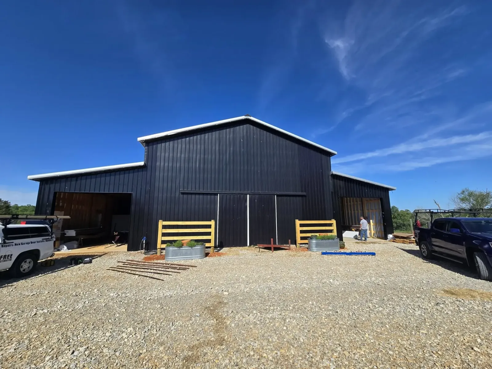 Black metal barn with new garage door openings in progress