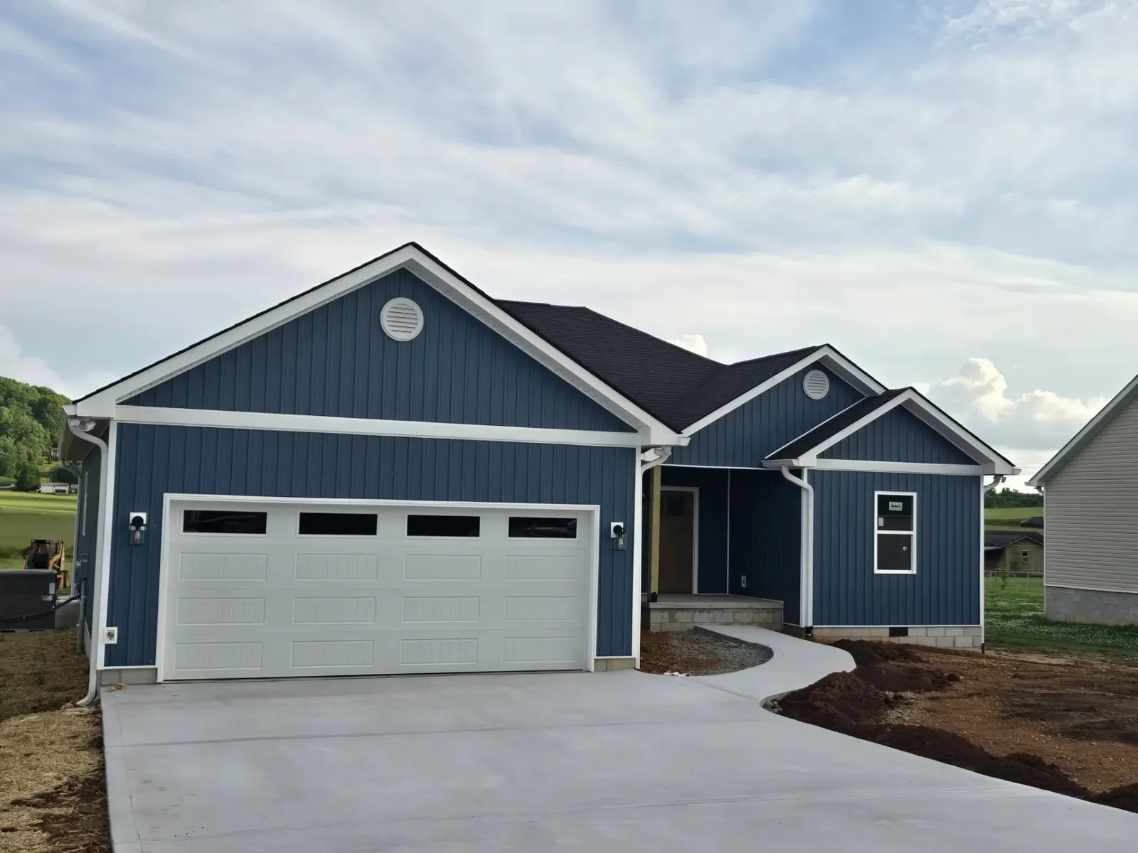 New white garage door installed on a blue craftsman home