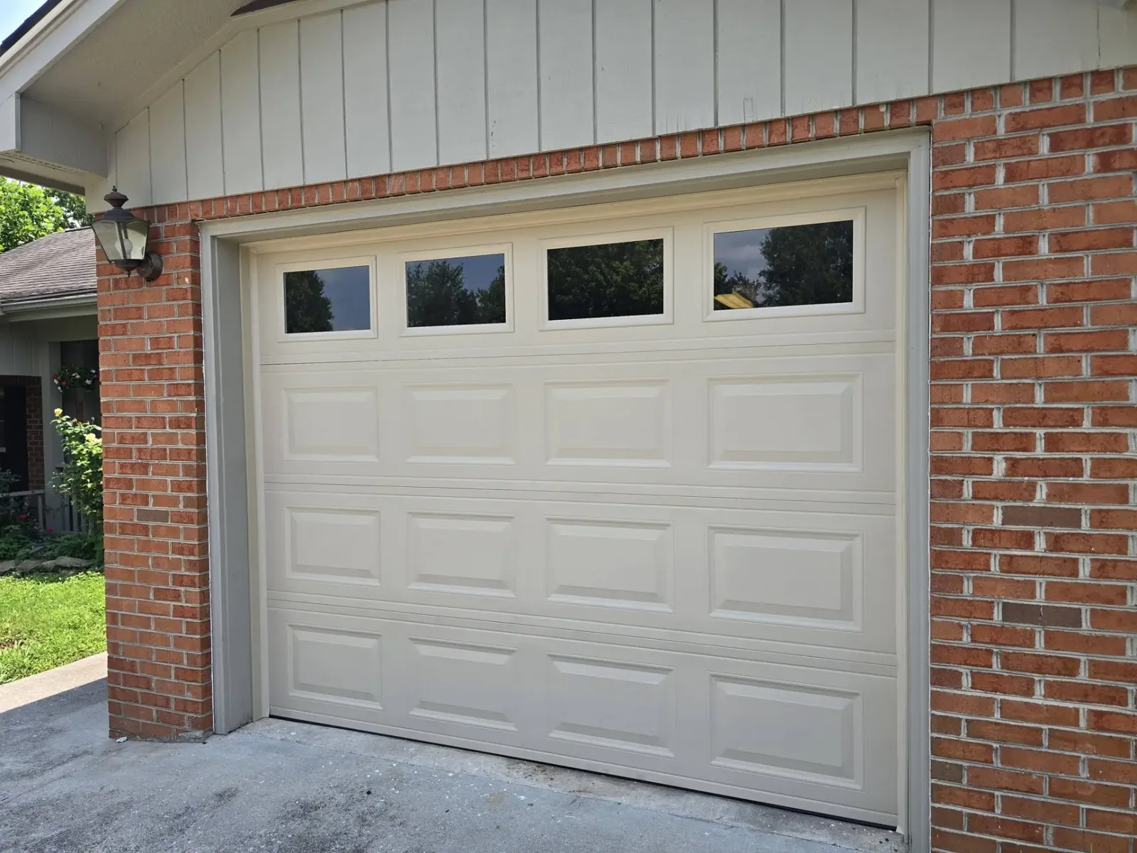 Beige single-car garage door with windows