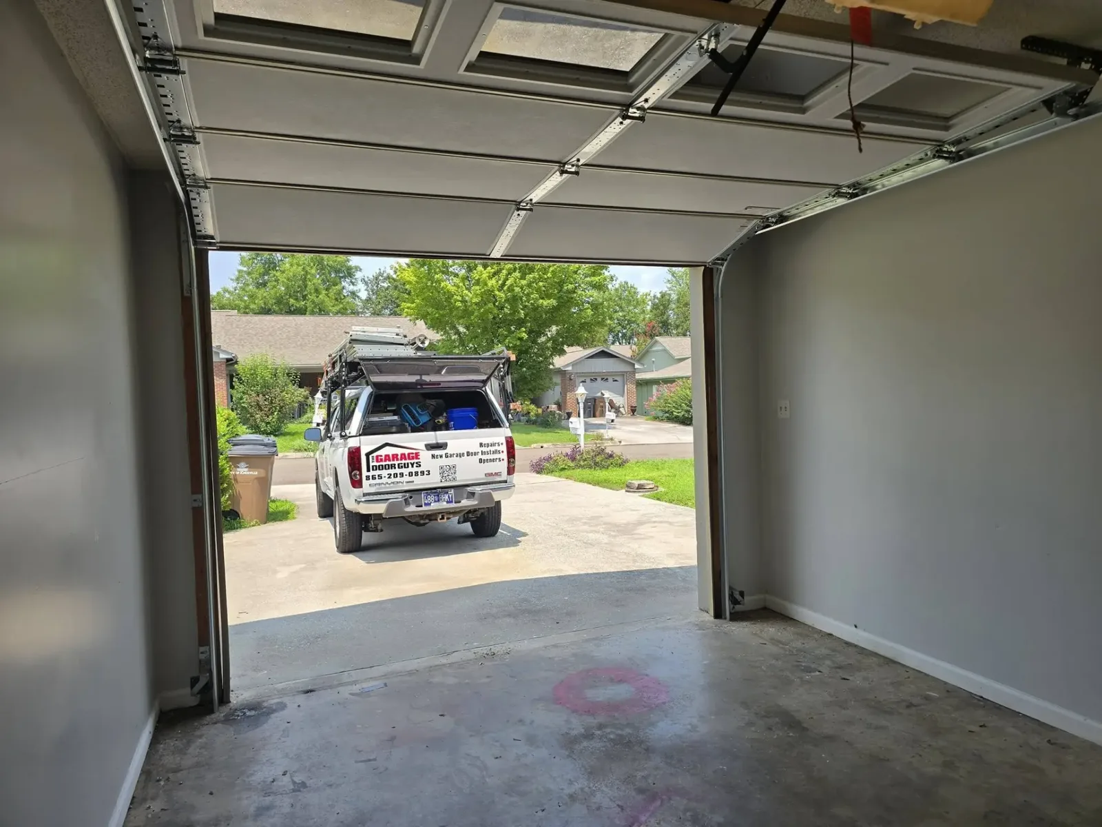View from inside an open garage looking out at the service truck