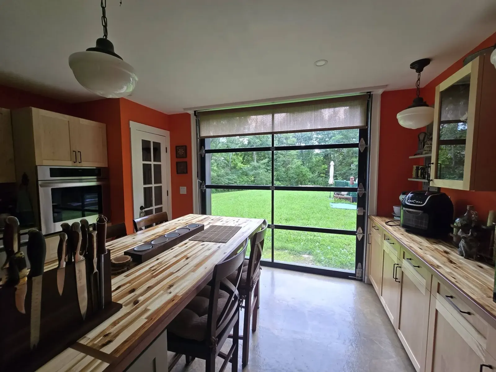 Full-view glass garage door installed in a kitchen and dining space
