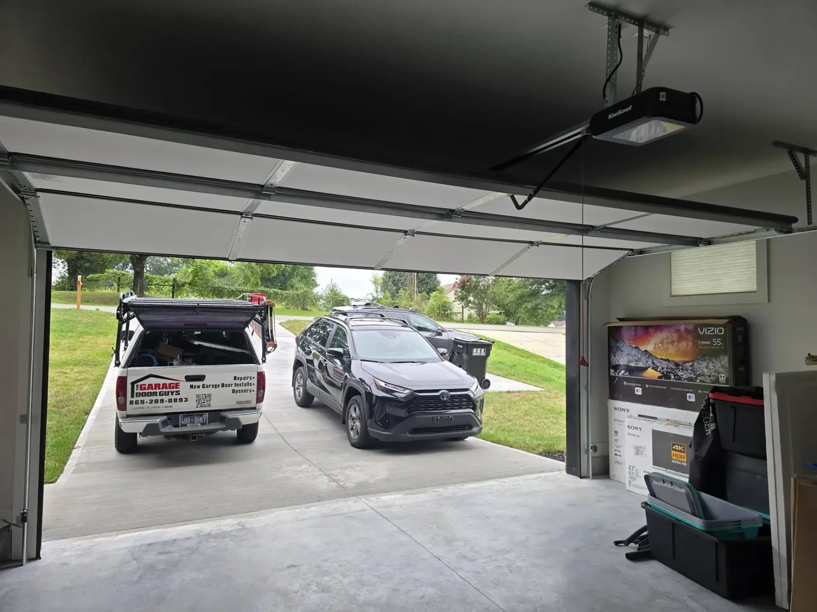 Garage interior showing the opener mechanism with the service truck parked outside